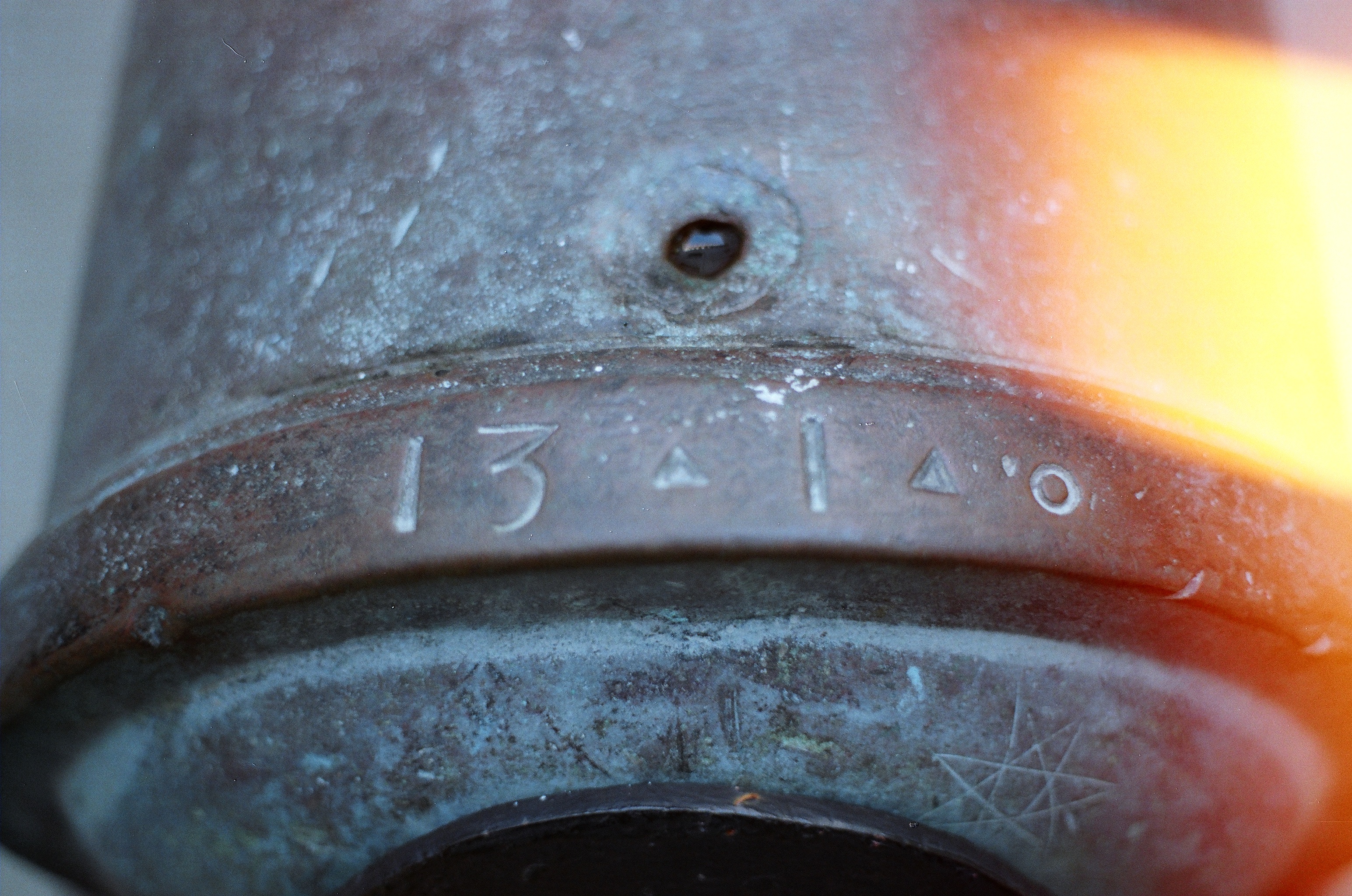Patinated metal object with engraved characters